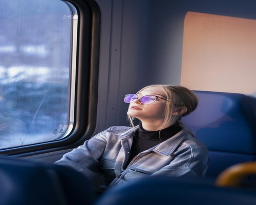 Person resting eyes while sitting comfortably on a city train commute